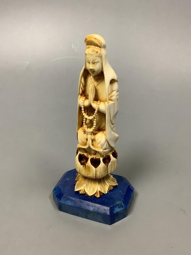 A 19th century Chinese carved ivory Guanyin, on a later lapis lazuli base, height 14cm